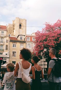 A group of tourists stands before a historic building in Lisbon, Portugal.